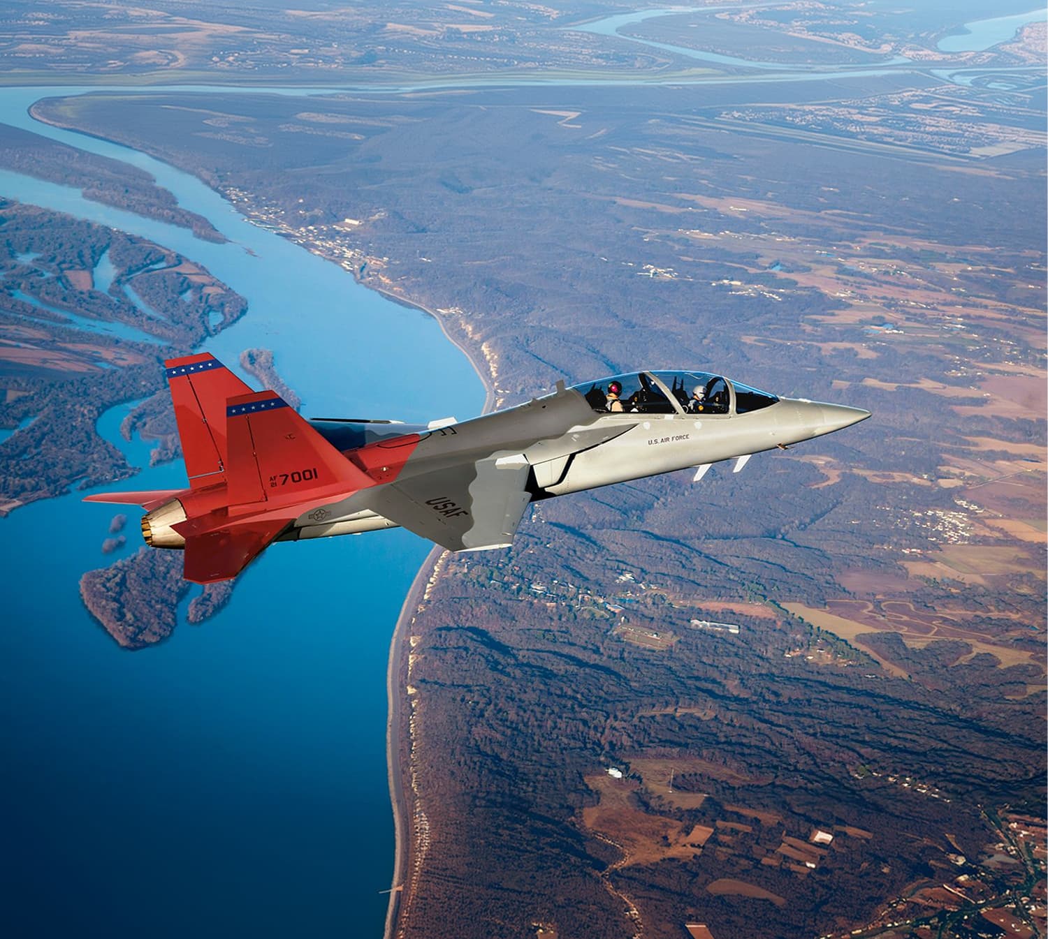 A Boeing T-7A Red Hawk trainer climbing against a blue sky