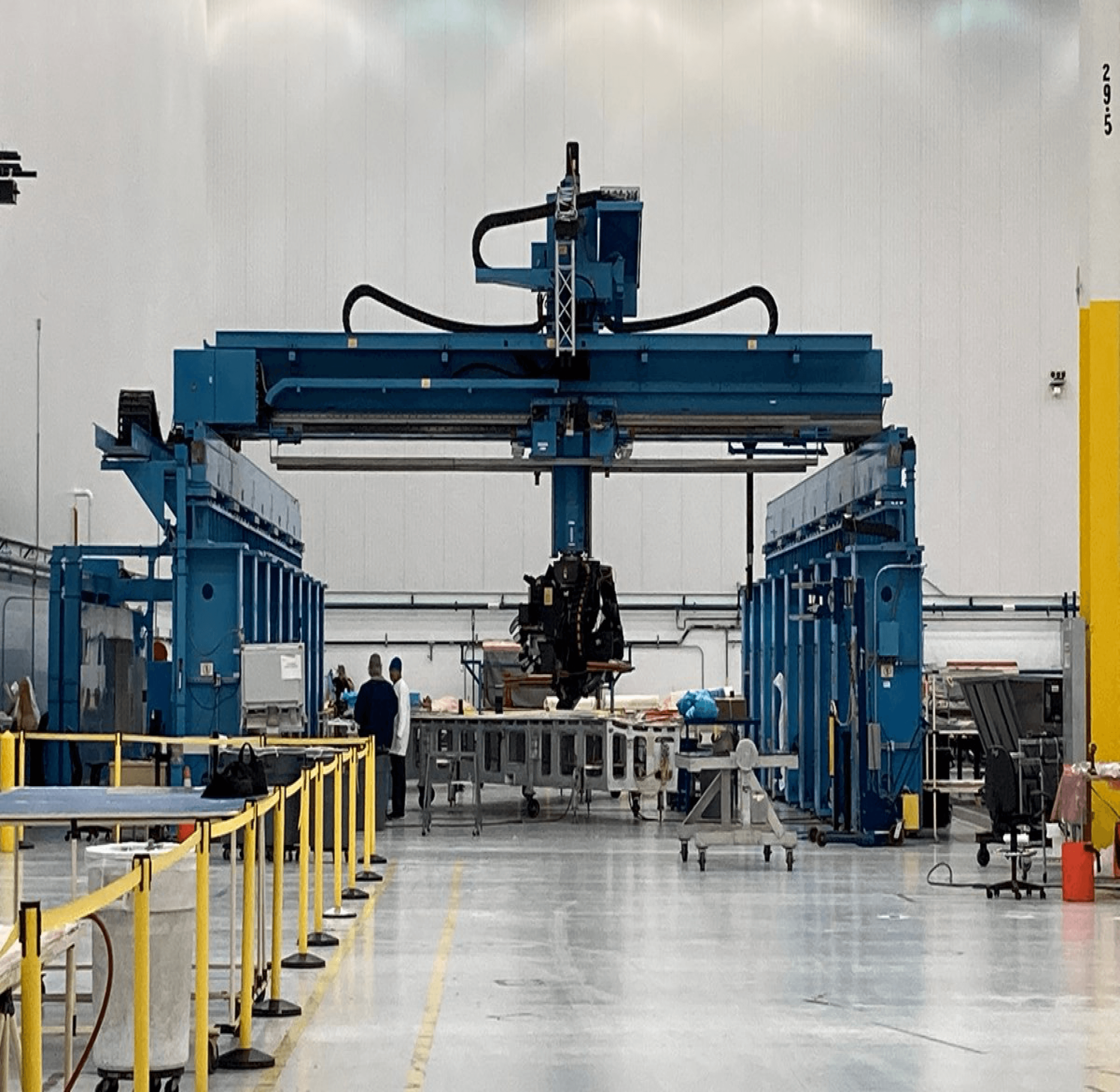 A gantry machine over a composite layup bed in a Qarbon Aerospace hall